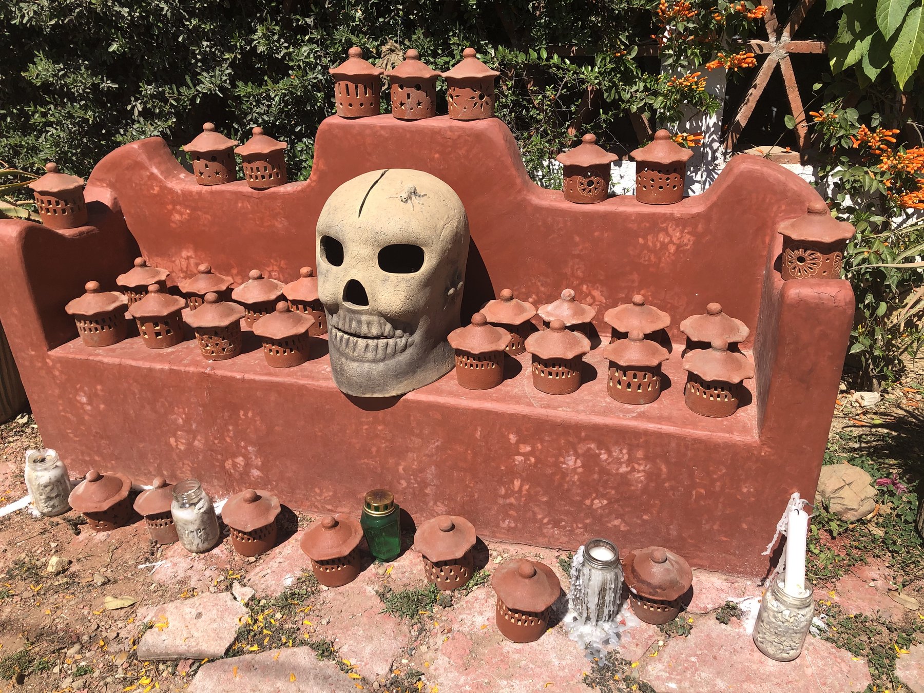 A Dia de los Muertos altar decorated with a skull and candle lanterns
