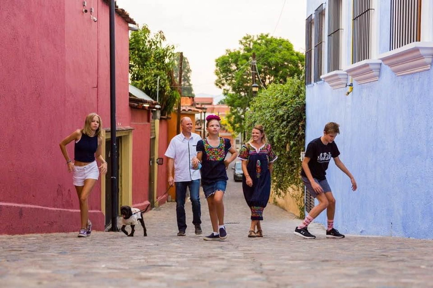 Our family and dog walking down a colorful street in Oaxaca